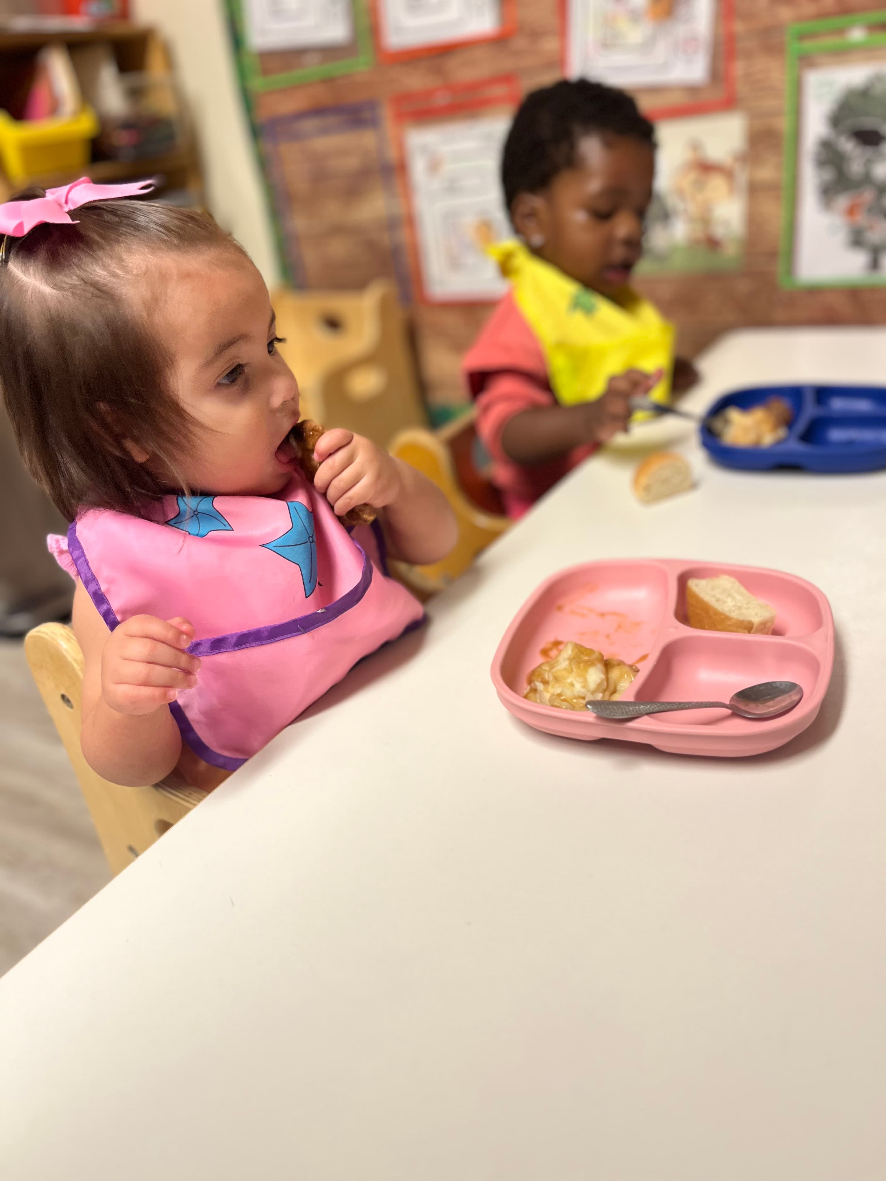 Two toddlers eating a home-cooked meal at ABQ Childcare
